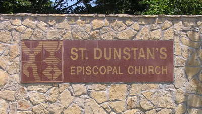 Carved stone sign reading St. Dunstan's Episcopal Church set into a rough stone wall